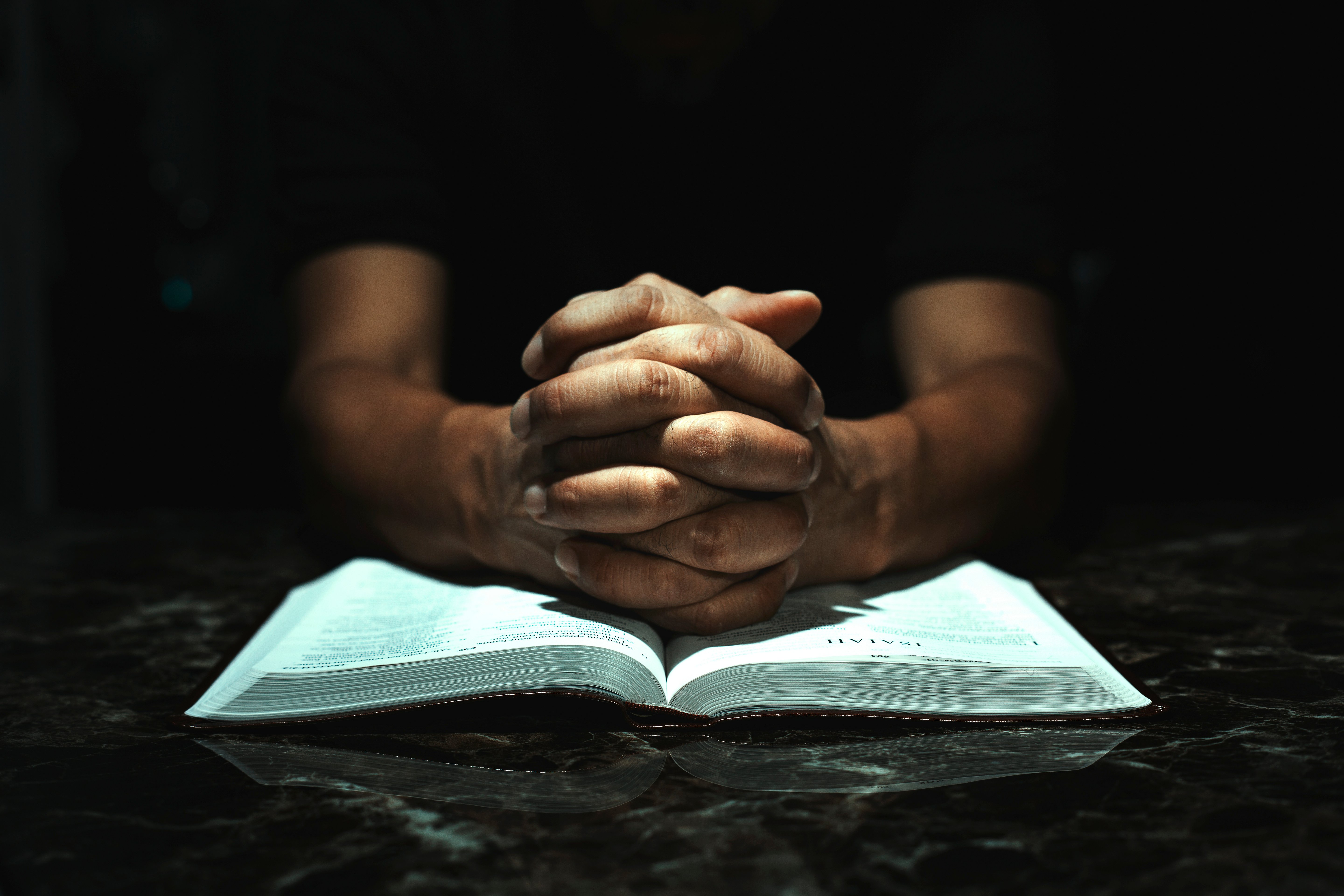 Men praying to God on his desk